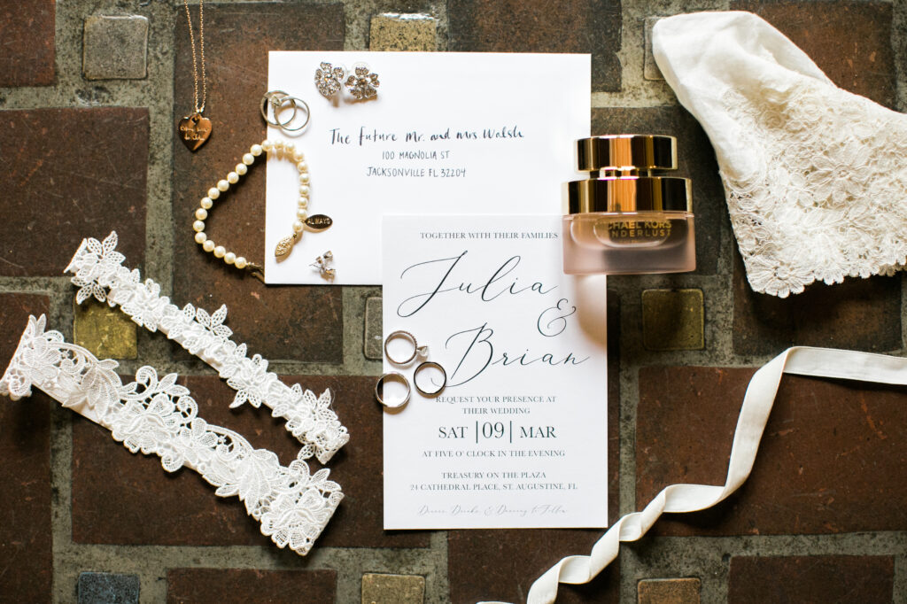 Invitation suite with rings, garter, and perfume